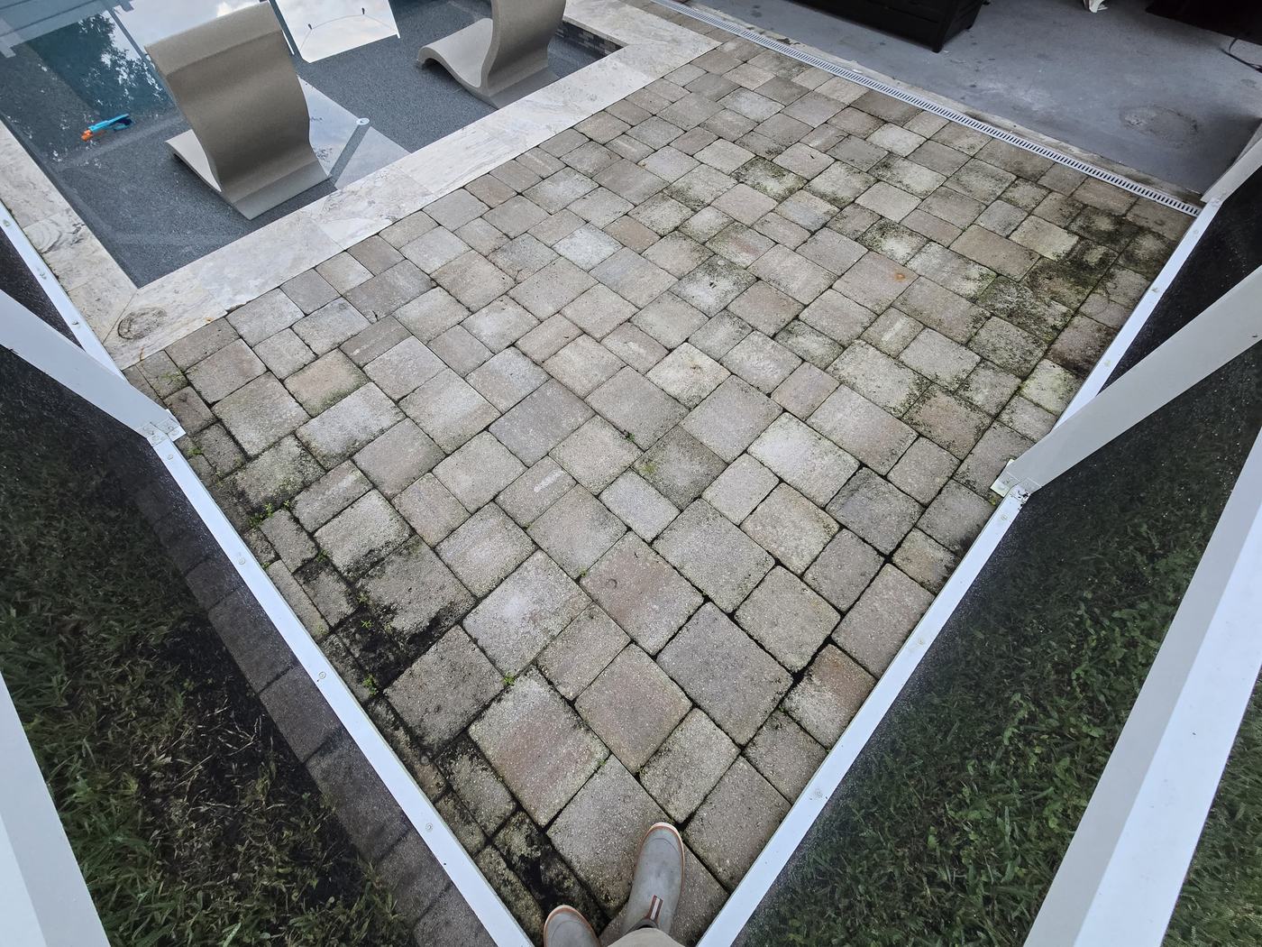 Pool patio pavers in Tampa stained with moss and weeds before paver cleaning and sealing